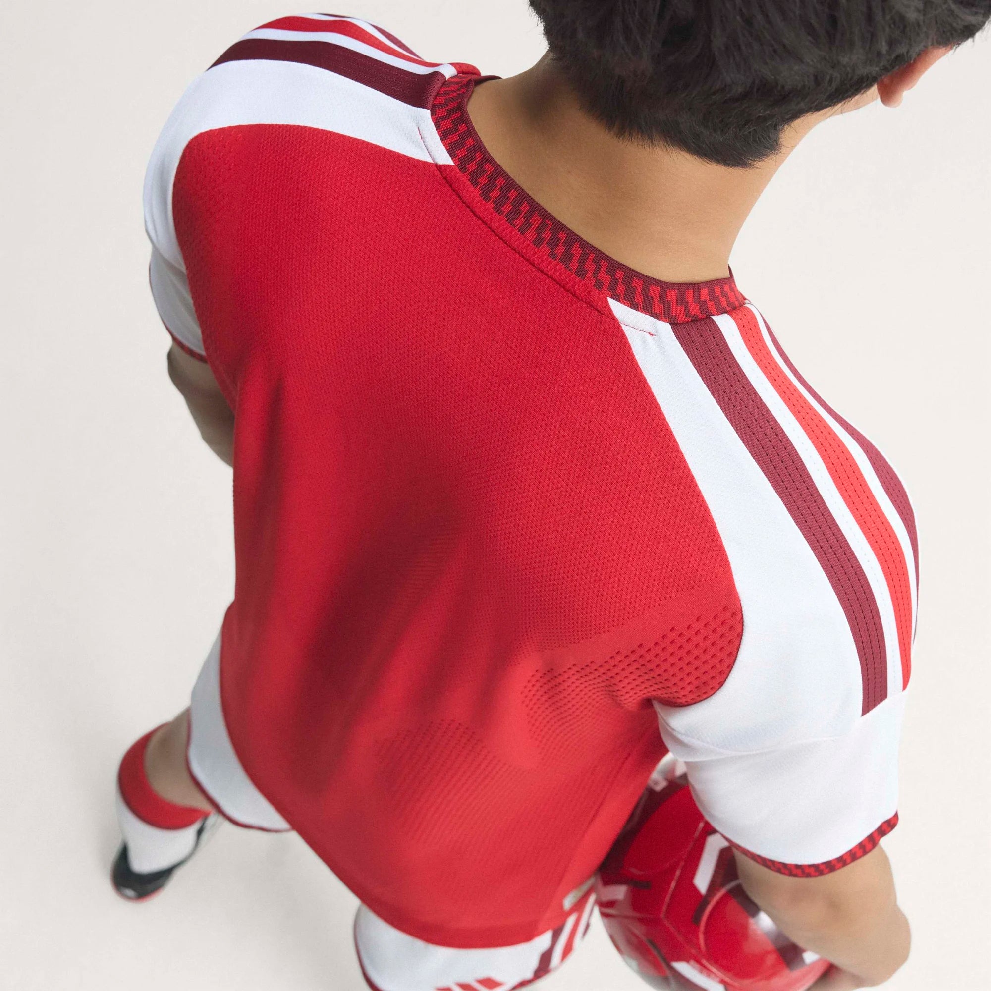 Red and white sports jersey with Adidas logo on a plain background