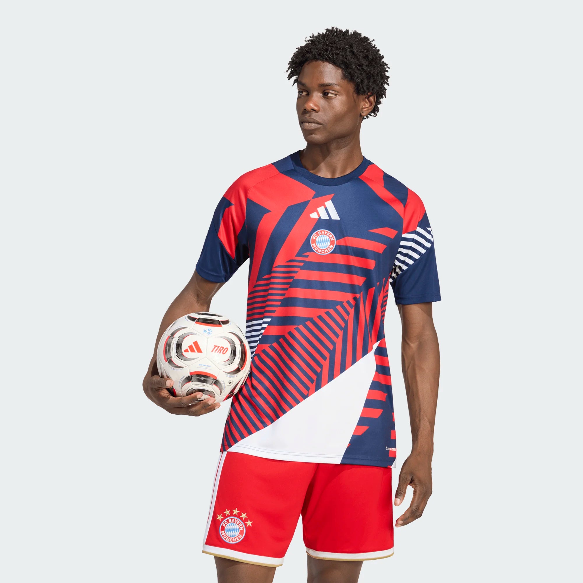Person wearing a red and blue sports outfit holding a soccer ball on a white background