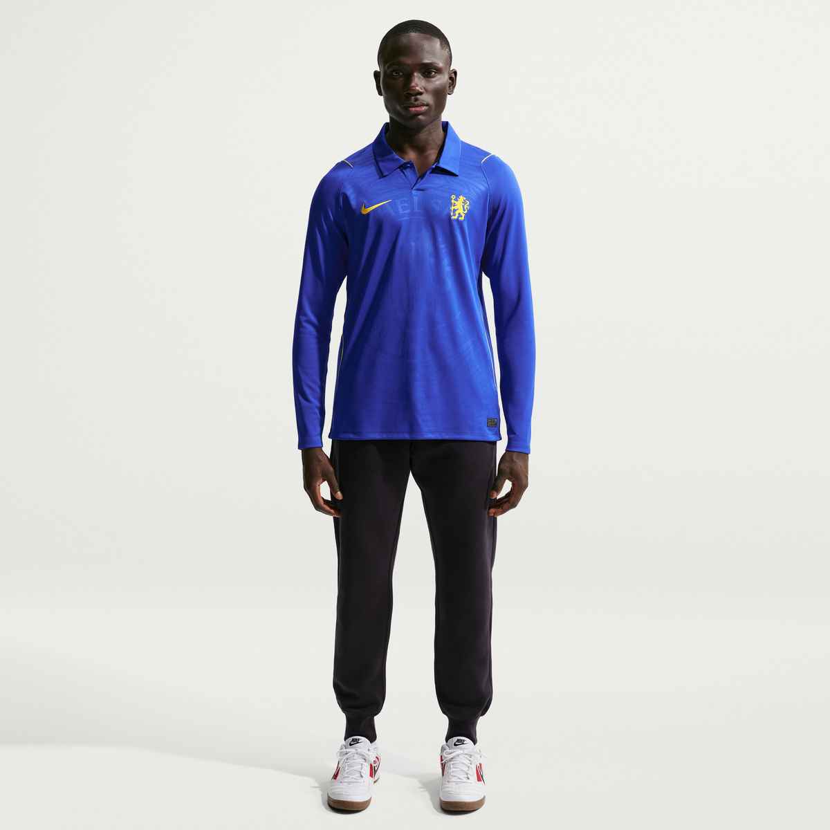 Person wearing a blue sports jersey with a logo on a white background